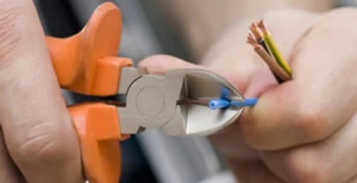 licensed electrician performing precise wire cutting and preparation during electrical service in Mesa, AZ